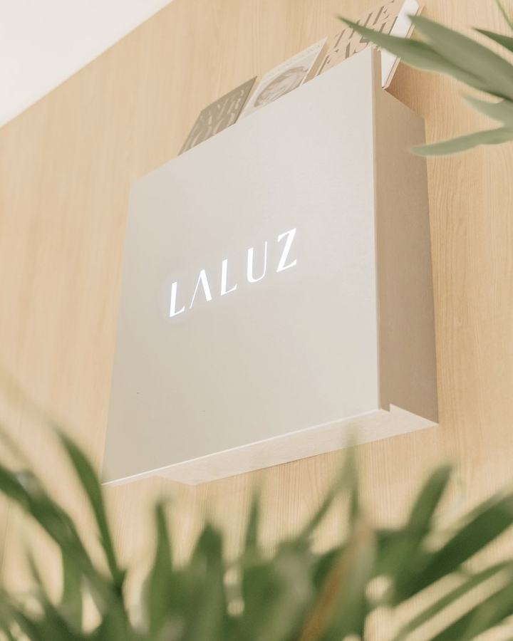 木目の壁に掛けられたLALUZのサイン