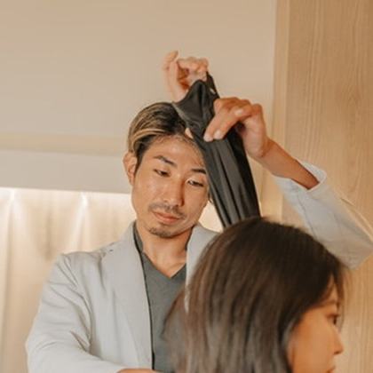 院長がお客様の腕を持ち上げ、肩の動きを確認する検査の様子